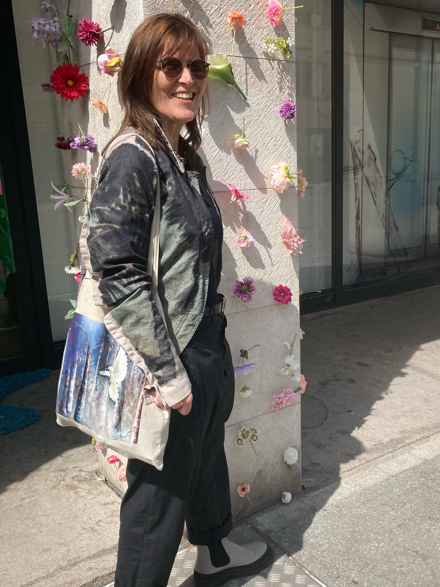 Barbara Scherrer vor einer mit Blumen geschmückten Wand